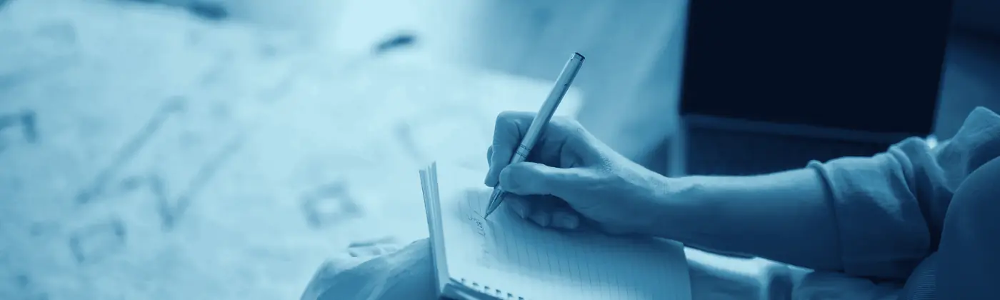 Manos escribiendo en un cuaderno